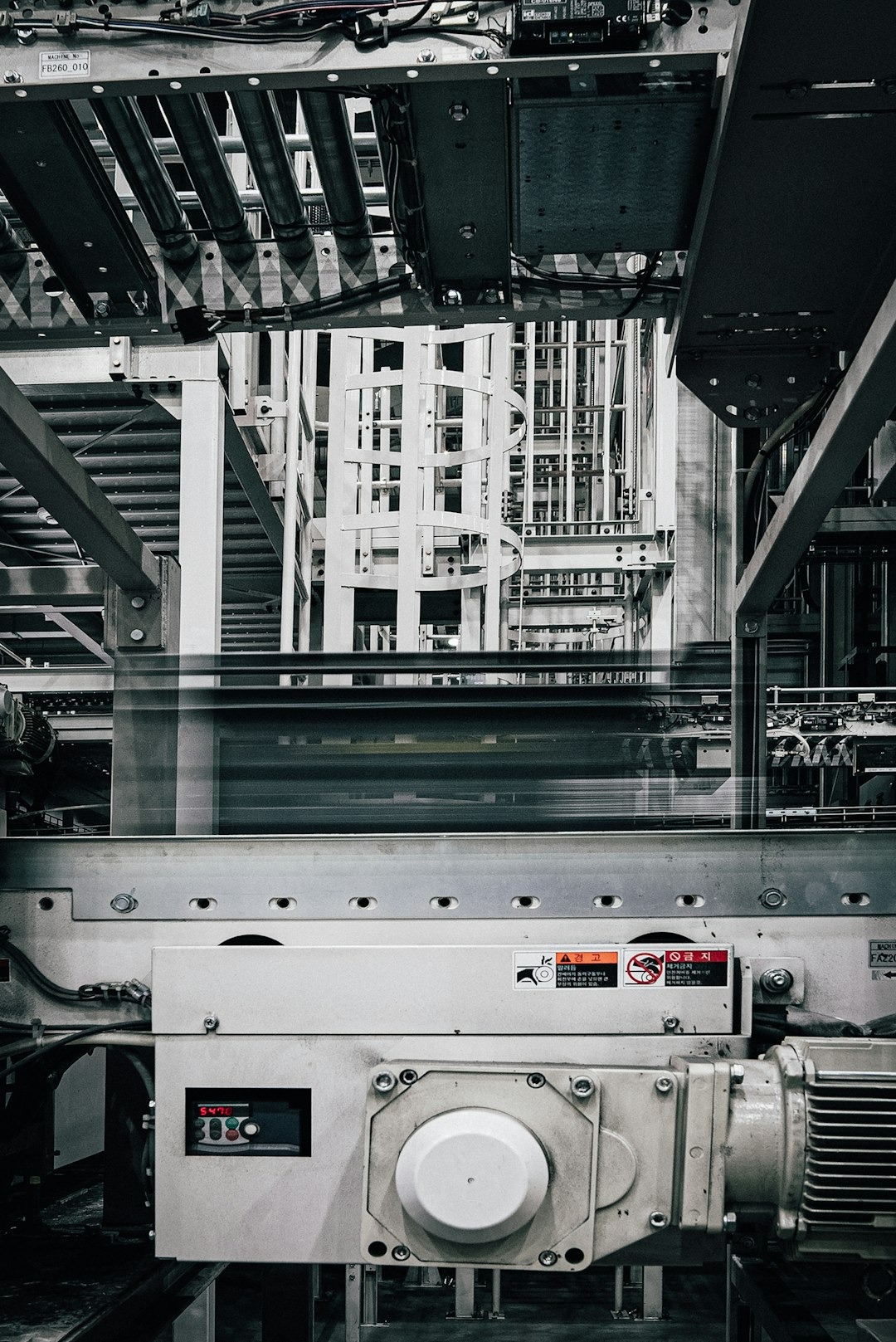 Intricate metal pipes and conveyor belts in a manufacturing plant.