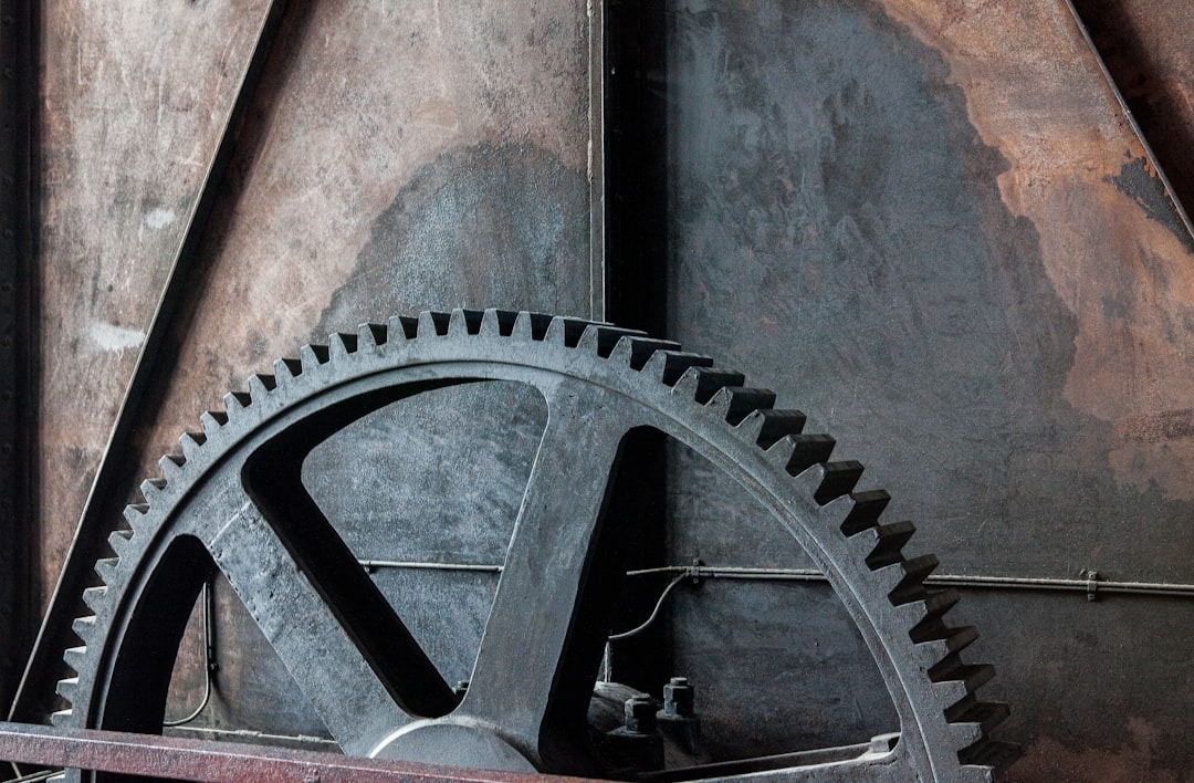 Large dark grey metal gear wheel with visible teeth.